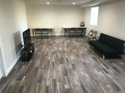 a room with a couch and tables and chairs at VWM Hostel in Los Angeles
