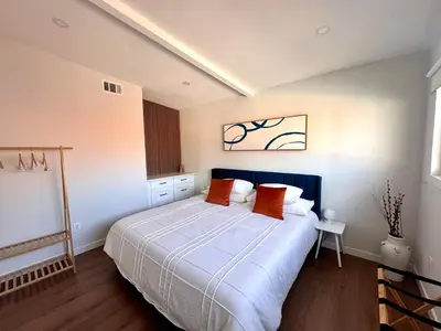 a bedroom with a large bed with orange pillows at 4 Bed Modern Pool House with Spa & Game Room in Northridge Hospital Heliport
