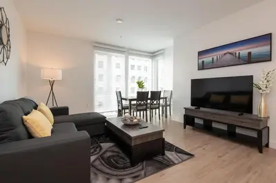 a living room with a couch and a flat screen tv at Chic 3-bed Apt with Pool & Hot Tub in Heart of DTLA in Los Angeles