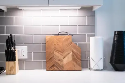 a wooden cutting board sitting on top of a kitchen counter at Chic 3-bed Apt with Pool & Hot Tub in Heart of DTLA in Los Angeles