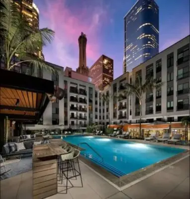 a large building with a swimming pool in a city at Chic 3-bed Apt with Pool & Hot Tub in Heart of DTLA in Los Angeles
