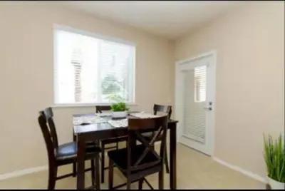a dining room with a table and chairs and a window at Spacious 2 Bedroom Apartment Near Disneyland and Anaheim Convention Center in Anaheim