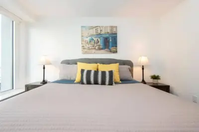 a bedroom with a large bed with yellow pillows at Modern 3 Bedroom High-Rise with resort Pool in Los Angeles