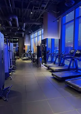 a gym with rows of exercise equipment and windows at Modern 3 Bedroom High-Rise with resort Pool in Los Angeles