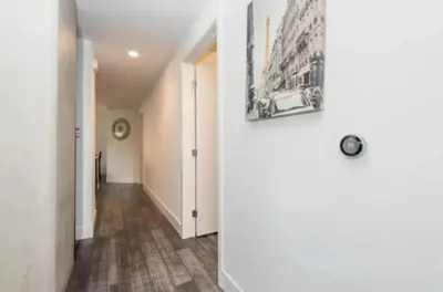 a hallway with white walls and a painting on the wall at Modern 3 Bedroom High-Rise with resort Pool in Los Angeles