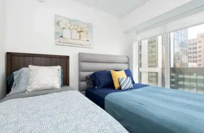 a bedroom with two beds and a window at Modern 3 Bedroom High-Rise with resort Pool in Los Angeles