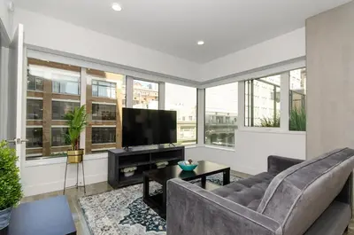 a living room with a couch and a flat screen tv at Stunning 3 Bedroom High-Rise with Pool, Spa, and Rooftop Views in Los Angeles