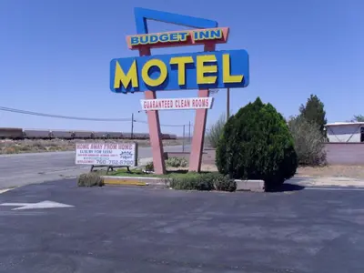 a motel sign in the middle of a parking lot at Budget Inn of Boron in Boron