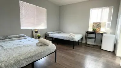 a room with two beds and two windows at The Disney Hostel - Fullerton - OC in Fullerton