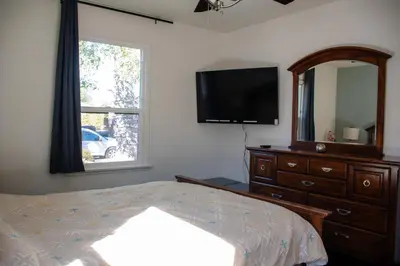 a bedroom with a bed and a dresser and a mirror at Cozy and Relaxing in Suburbs of LA in Mission Hills