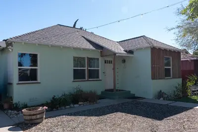 a white house with a brown roof at Cozy and Relaxing in Suburbs of LA in Mission Hills