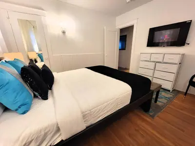 a bedroom with a bed with a tv on the wall at Spacious 5BR Private Home 5 minutes to Rodeo Drive with Hot Tub Spacious Backyard Parking in Los Angeles