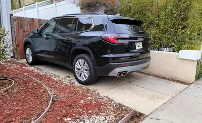a black car parked next to a fence at Spacious 5BR Private Home 5 minutes to Rodeo Drive with Hot Tub Spacious Backyard Parking in Los Angeles