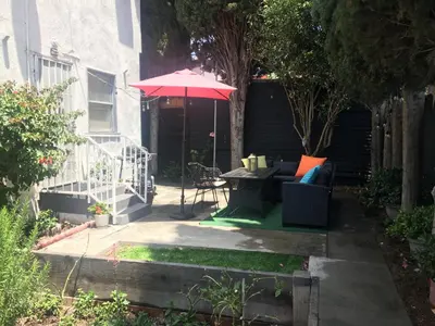 a patio with a table and a red umbrella at 4bed 2ba Hollywood house Block away from sunset, Free parking, private backyard in Los Angeles