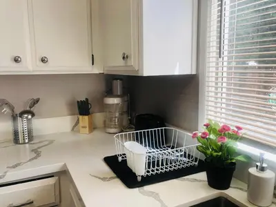 a kitchen counter with a sink with flowers on it at 4bed 2ba Hollywood house Block away from sunset, Free parking, private backyard in Los Angeles