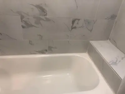 a white bath tub in a bathroom with marble tiles at 4bed 2ba Hollywood house Block away from sunset, Free parking, private backyard in Los Angeles