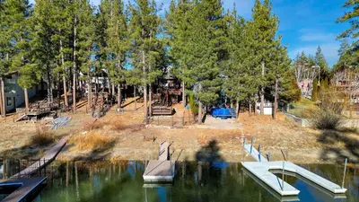 a park with a playground and a boat in the water at Lakefront w Private Dock Hot Tub Large Deck Views Lakeside on Lagunita in Big Bear Lake