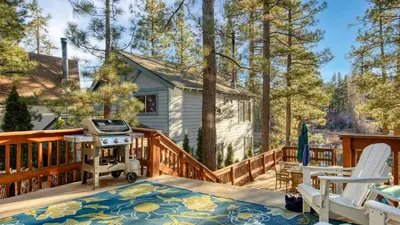 a backyard deck with a grill and two chairs at Lakefront w Private Dock Hot Tub Large Deck Views Lakeside on Lagunita in Big Bear Lake