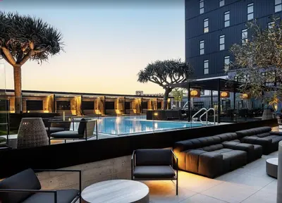 a hotel with a pool and chairs and a building at Modern Stay in Arts District LA in Los Angeles
