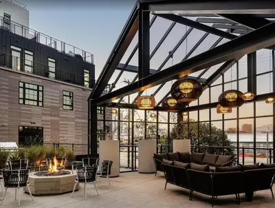 a patio with a fire pit and chairs and a building at Modern Stay in Arts District LA in Los Angeles