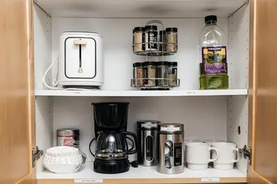 a cupboard with a coffee maker and other items at Seaside Serenity - Chic Santa Monica Studio in Los Angeles