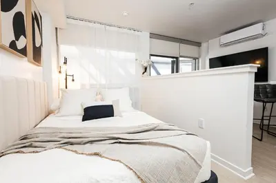 a bedroom with a white bed with a pillow on it at Seaside Serenity - Chic Santa Monica Studio in Los Angeles