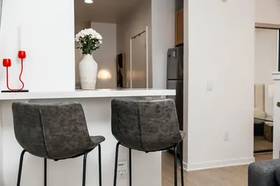 a kitchen with two gray chairs and a counter at Seaside Serenity - Chic Santa Monica Studio in Los Angeles