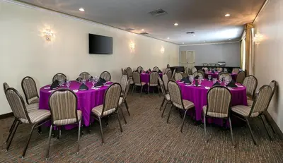a conference room with purple tables and chairs at Pacific Stay Hotel in West Covina