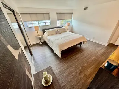 a bedroom with a bed and two windows at Masion de Beverly Hills in Los Angeles