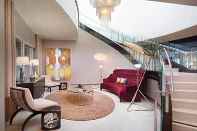 a living room with a red couch and a staircase at SpringHill Suites by Marriott Los Angeles Burbank/Downtown in Burbank