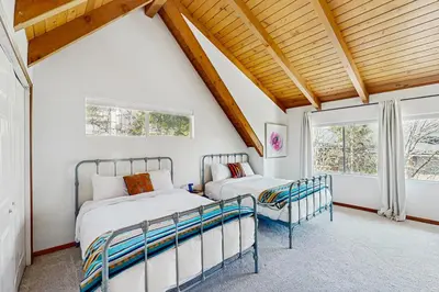 two beds in a room with two windows at Arrowhead Aura in Lake Arrowhead