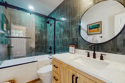 a bathroom with a sink and a mirror and a toilet at Arrowhead Aura in Lake Arrowhead