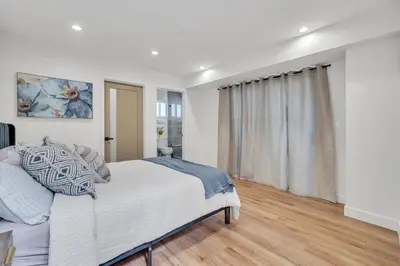 a white bedroom with a bed and a window at Luxe Townhome Newly-Built in Sherman Oaks Community Hospital Heliport