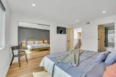 a bedroom with a large bed and a mirror at Luxe Townhome Newly-Built in Sherman Oaks Community Hospital Heliport