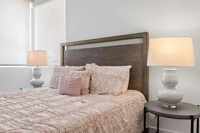 a bedroom with a bed with two lamps and two tables at 8 Santa Monica Huge Stylish Apartment in Los Angeles