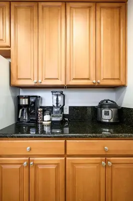 a kitchen with wooden cabinets and a counter top at Comfortable Home Near LA with Full Kitchen & Laundry in Alhambra