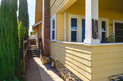 a yellow house with a sign on the side of it at Comfortable Home Near LA with Full Kitchen & Laundry in Alhambra