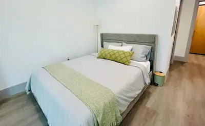 a bedroom with a large bed with white sheets and yellow pillows at New Lux Skyline Loft in LA in North Sherman Way