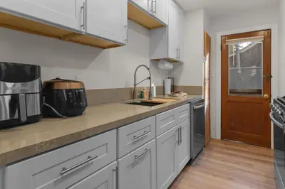 a kitchen with white cabinets and a sink at Big Bear Cottage - Walk to Lake, Smart TV, Fireplace, Deck in Big Bear Lake