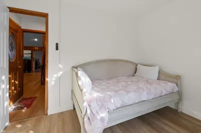 a bed sitting in a room with a mirror at Big Bear Cottage - Walk to Lake, Smart TV, Fireplace, Deck in Big Bear Lake
