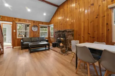 a living room with a table and a fireplace at Big Bear Cottage - Walk to Lake, Smart TV, Fireplace, Deck in Big Bear Lake
