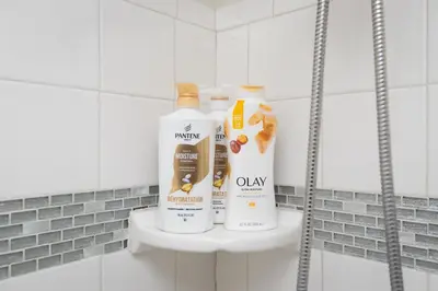 two bottles of cleaning products sitting on a shelf in a bathroom at Sunny SoCal Escape 3BR 2BA Bright home with pool in Winnetka