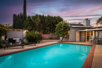 a swimming pool in the backyard of a house at Sunny SoCal Escape 3BR 2BA Bright home with pool in Winnetka