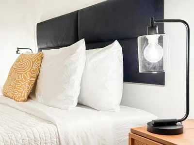 a bed with white pillows and a lamp on a table at Charming 4 Bedrooms Family House - WIL-WW in Los Angeles