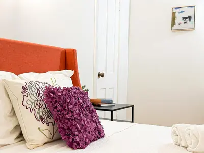 a bed with a pillow with purple flowers on it at Elegant 4-Bedroom with Courtyard - WIL- BEV in Los Angeles