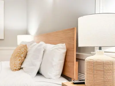 a bed with white pillows and a lamp on a table at Elegant 4-Bedroom with Courtyard - WIL- BEV in Los Angeles