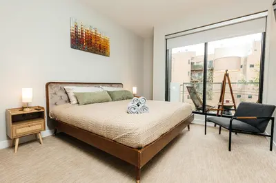 a bedroom with a bed and a chair and a window at Magnificent two bedroom in West Hollywood in Los Angeles