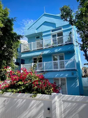 a blue house with flowers in front of it at Luxe 2-BR with King suite, rooftop, steps from beach in Los Angeles