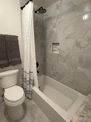 a bathroom with a white toilet and a shower at Luxe 2-BR with King suite, rooftop, steps from beach in Los Angeles