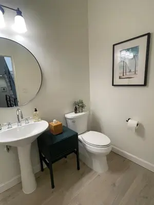 a bathroom with a toilet and a sink and a mirror at Luxe 2-BR with King suite, rooftop, steps from beach in Los Angeles
